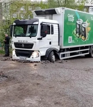 На улице Коммунальная грузовик провалился передними колёсами в глубокий провал грунта между домами. Разнорабочие оградили яму, администрация направила погрузчик.